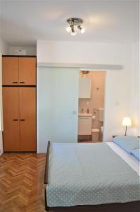 een slaapkamer met een bed, een dressoir en een badkamer bij Apartment Marija in Krk