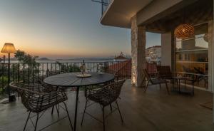 een patio met een tafel en stoelen op een balkon bij TIS YAYAS apartments in Pylos