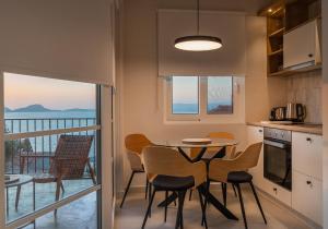 een keuken met een tafel en stoelen en een balkon bij TIS YAYAS apartments in Pylos