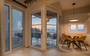 a dining room with sliding glass doors and a table and chairs at TIS YAYAS apartments in Pylos