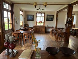 a dining room with wooden tables and chairs at Estancia Nibepo Aike in Colonia Francisco Perito Moreno