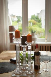 奧勒松的住宿－Light Sentral Apartment Ålesund，一张桌子,上面放着两根蜡烛和一瓶葡萄酒