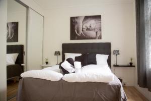 una camera da letto con un grande letto con cuscini bianchi di Light Sentral Apartment Ålesund ad Ålesund