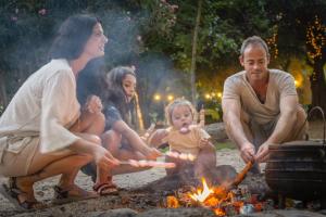 a group of people sitting around a campfire at Camping Dafna - By Travel Hotel Chain in Dafna