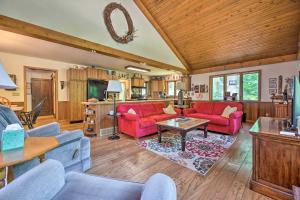 una sala de estar con muebles de color rojo y techo de madera. en Corey Lake Home, 7 Mi to Swiss Valley Ski Resort!, en Three Rivers