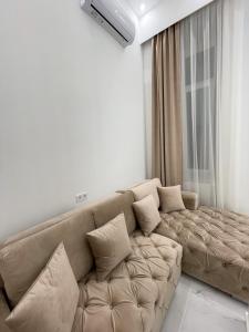 ein Wohnzimmer mit einem braunen Sofa und einem Fenster in der Unterkunft St Stephen Luxury Apartment in Budapest