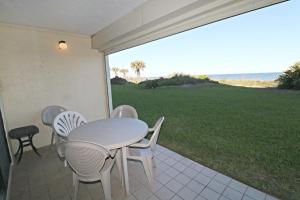 Una mesa y sillas en un patio con vista al mar. en Sand Dollar 1-105, en St. Augustine