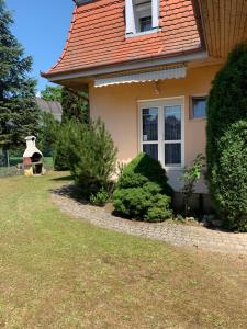 a house with a red roof and some bushes at Anno 2000 in Balatonlelle