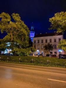 a street in front of a building with a clock tower at Várker 9 Apartman in Sopron