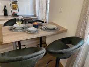 a table with two chairs and a table with wine glasses at Várker 9 Apartman in Sopron