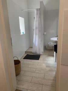 ein Bad mit einer weißen Dusche und einem Waschbecken in der Unterkunft Várker 9 Apartman in Sopron
