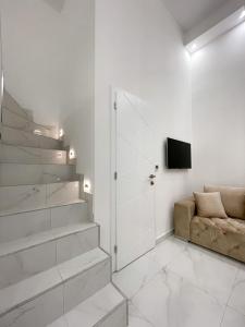ein weißes Wohnzimmer mit einem Sofa und einem TV in der Unterkunft St Stephen Luxury Apartment in Budapest
