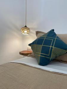 almohada azul y amarilla sobre una cama en Villa stou Chiou, en Agia Anna de Naxos