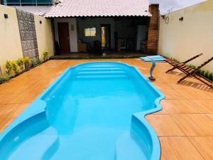 a blue swimming pool in the middle of a yard at CASA DE PRAIA CORURIPE - LAGOA DO PAU in Coruripe