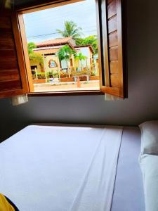 科魯里皮的住宿－CASA DE PRAIA CORURIPE - LAGOA DO PAU，从带大楼的房间的窗户欣赏美景