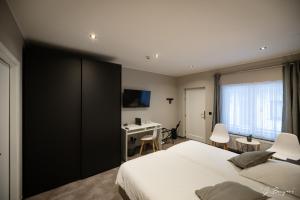 斯帕La Reine Hôtel & Restaurant的卧室里有一张床和一张书桌