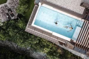 una vista panoramica di 2 persone che nuotano in una piscina di Stoa - Elegant & Romantic Guest House - "Adults only" a San Vigilio Di Marebbe