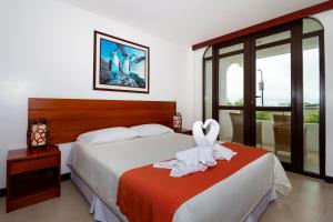 a hotel room with a bed with towels on it at Galapagos Apartments - Bay View House in Puerto Ayora