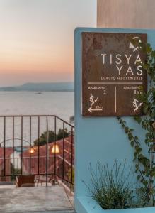 ein Schild vor einem Gebäude mit Meerblick in der Unterkunft TIS YAYAS apartments in Pylos