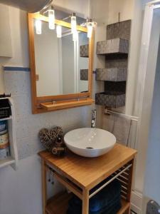 ein Bad mit einem Waschbecken und einem Spiegel in der Unterkunft Appartement pleine vue mer au bord de la plage in Binic
