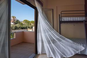 a bedroom with a window with a mosquito net at Libyan Sea Luxury Apartment 2 in Ierápetra