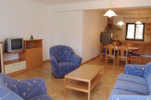 a living room with blue chairs and a table at Turistična kmetija Birsa in Dobravlje