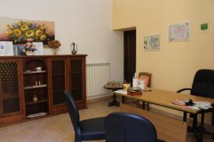 アレッツォにあるLa Corteのテーブルと椅子、テーブルと棚が備わる客室です。