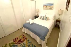 a bedroom with a white bed with a blue blanket at KASA Charming Luna 2 bedroom in San Juan