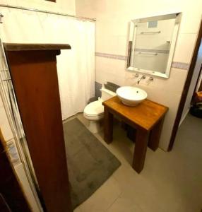 baño con lavabo y aseo con espejo en KASA Charming Luna 2 bedroom, en San Juan