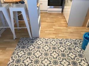 a kitchen floor with a rug on the floor at La maison de Sloan in Guéret