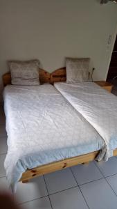 a large bed with a wooden frame in a bedroom at Le Petit Atelier in Excénevex