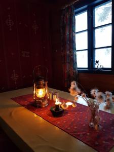 een tafel met kaarsen en een lantaarn op een tafel bij Hytte ved innsjø in Landsem