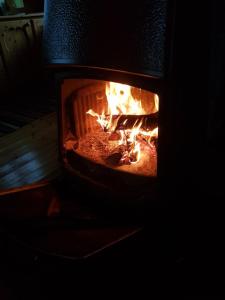 een bakstenen oven met een vuur erin bij Hytte ved innsjø in Landsem