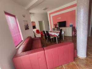 uma sala de estar com um sofá vermelho e uma mesa em APP Margareta em Umag