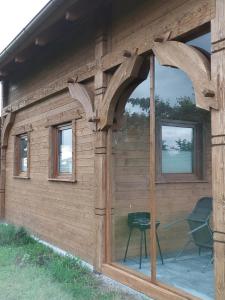 een houten huis met een raam en een stoel erin bij Przytulisko in Smołdzino