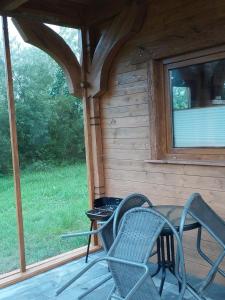 een patio met stoelen en een tafel in een hut bij Przytulisko in Smołdzino