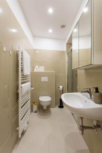 Un baño blanco con lavabo e inodoro. en Servus at Naschmarkt II, en Viena