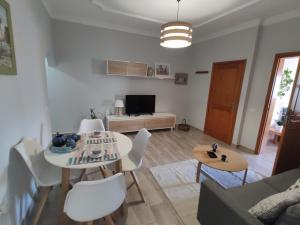 een woonkamer met een tafel en stoelen en een bank bij Gran Canaria - Casa Carmen (Vecindario) in Vecindario