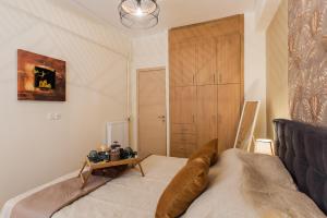 a bedroom with a bed and a wooden closet at Lovely renovated apartment walk to Acropolis in Athens