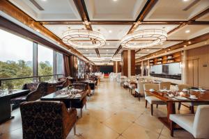 a restaurant with tables and chairs and windows at Holiday Inn Changzhou Wujin by IHG in Changzhou