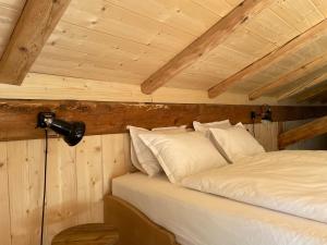 a bed in a room with a wooden ceiling at STUBN in der Frasdorfer Hütte in Frasdorf