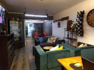 ein Wohnzimmer mit zwei Sofas und einer Uhr an der Wand in der Unterkunft Casa Roble Añejo Bed & Breakfast in Santa Cruz