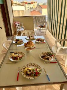 un tavolo con piatti di cibo su un balcone di Attico centralissimo e vicino al mare ad Alghero