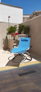 Leporano Marina的住宿－Casa vacanze Nonna Titina，坐在街道边的蓝色椅子