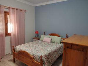 a bedroom with a bed and a table and a window at Gran Canaria - Casa Carmen (Vecindario) in Vecindario