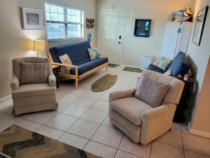 ein Wohnzimmer mit 2 Stühlen und einem Sofa in der Unterkunft Hacienda del Sol II - 103 in New Smyrna Beach
