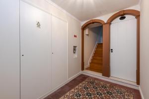 een hal met witte muren en een deur en een tapijt bij Ponto Alto Apartments in Lissabon +21 foto's