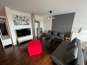 a living room with a couch and a red rug at Penthouse-Wohnung - Balkon - Dachterrasse - Zentrum in Nuremberg