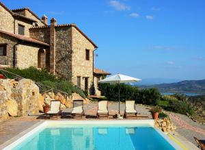 a pool in front of a house with chairs and an umbrella at I Casali Di Colle San Paolo in Tavernelle