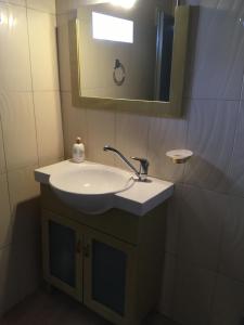 a bathroom with a sink and a mirror at Leonidas apartments 1 in Sparti